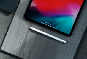 black iPad and white Apple Pencil on gray table