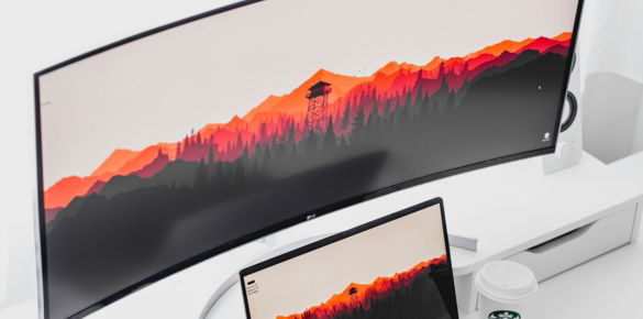 laptop computer beside curved monitor